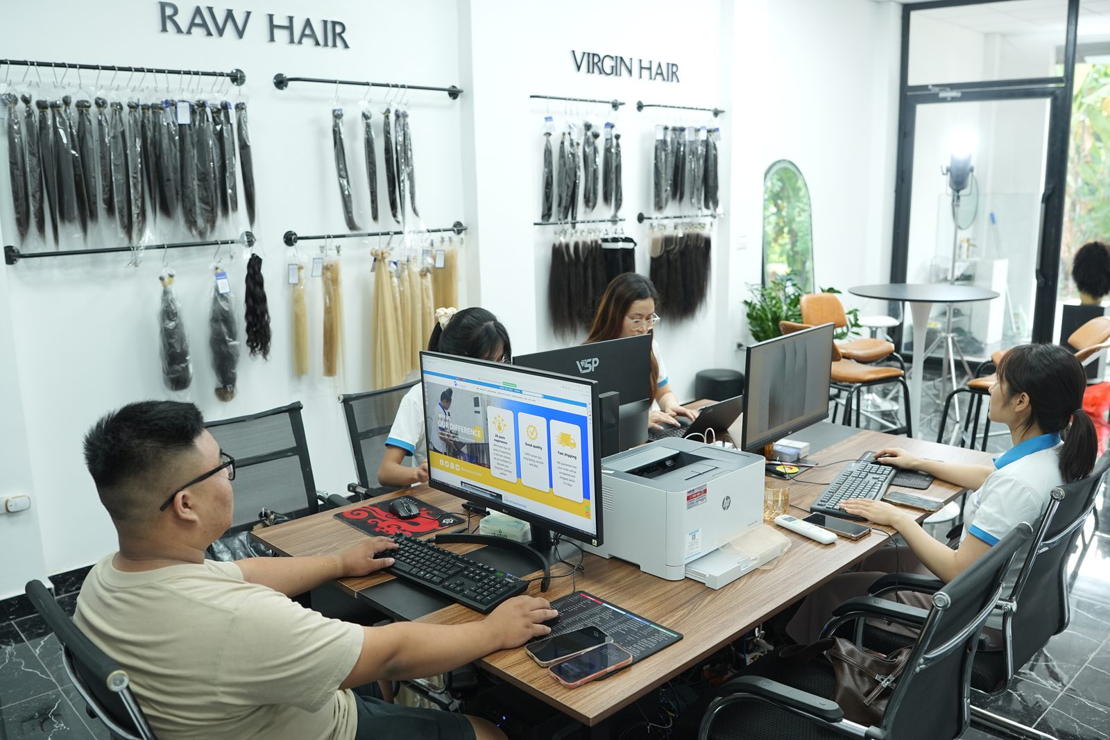 Wall displays of hair bundles hanging in clear bags under signs reading Raw Hair and Virgin Hair
