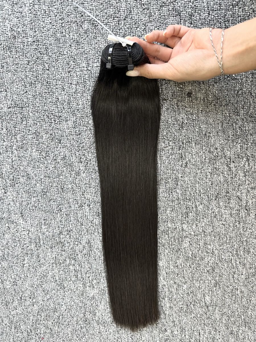 A long straight dark hair bundle held up by the weft to show its full length